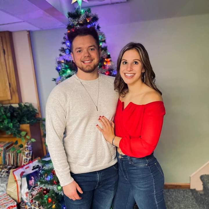 Alyssa Jagoda and Zack Banaszack pose in front of their Christmas tree.