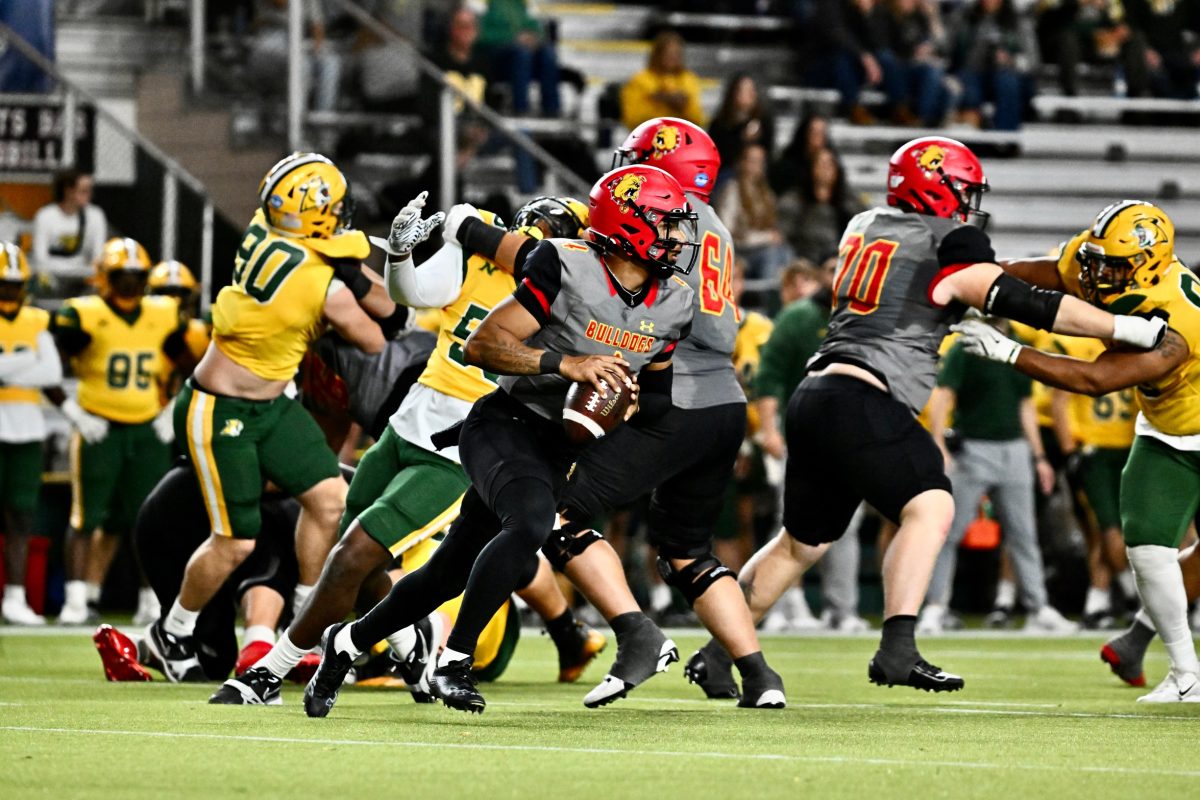 Junior Quarterback Trinidad Chambliss sprints past a Northern Michigan defensive linemen.